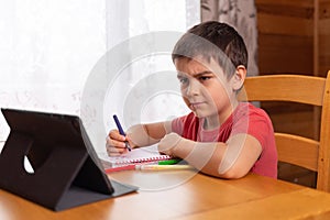 Preschool boy learning at home. online remote school. doing homework