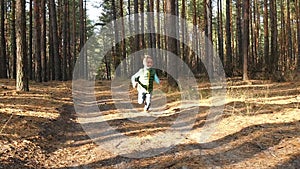 A preschool boy runs along the road in a forest or park, experiencing emotions: happiness, joy and laughter. Kids games