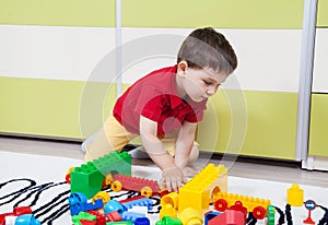 Preschool boy who build towers with plastic cubes