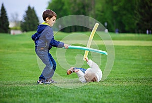 Preschool boys fighting with toy swords