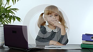 Preschool child girl distance online learning at home. Kid studying using digital laptop computer