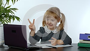 Preschool child girl distance online learning at home. Kid studying using digital laptop computer