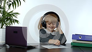 Preschool child girl distance online learning at home. Kid studying using digital laptop computer