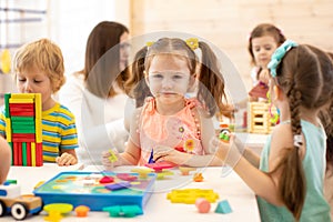 Preschool children play with colorful didactic toys at kindergarten photo