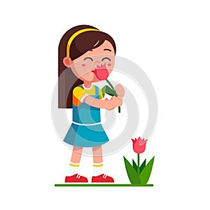 Girl kid holding tulip flower and smelling it