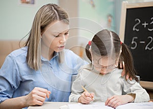 Preschool home education. Beautiful young girl is teaching at h