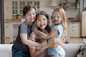 Preschool kids hugging beautiful mother family sitting on couch