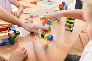Preschool teacher with children playing with colorful wooden didactic toys at kindergarten photo