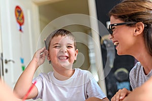 Preschool teacher looking at smart child at kindergarten