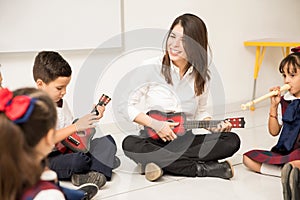Preschool teacher playing the guitar in class
