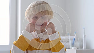 Preschooler boy cleaned teeth with dental floss and then is brushing his teeth with toothbrush carefully. Learning children proper