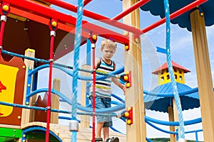 Preschooler boy inside climbing net in the nature