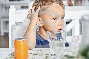 Preschooler boy sits in hotel restaurant waiting for order