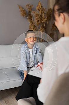 Preschooler boy visiting psychotherapist, woman and child talking about problem, psychotherapy session in office, kid