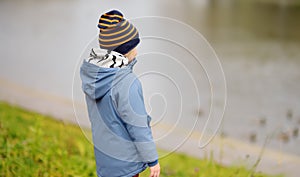 Preschooler boy walking in autumn park. Outdoor activities for children