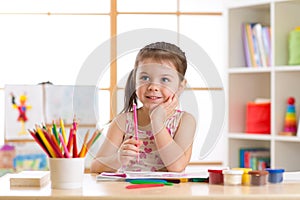 Preschooler child drawing and coloring by pencils