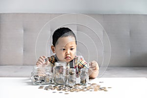 Preschooler child learning to calculate personal budget, manage finance, playing investment, accounting. Focused school kid saving