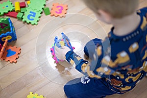 Preschooler child playing with colorful toy blocks. Kid playing with educational wooden toys