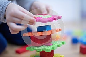 Preschooler child playing with colorful toy blocks. Kid playing with educational wooden toys