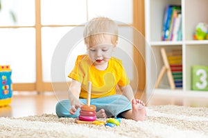 Preschooler child playing with colorful toy. Kid playing with educational wooden toy at kindergarten or daycare center. Toddler in