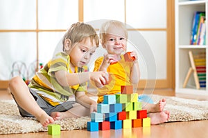 Preschooler children playing with colorful toy blocks. Kid playing with educational wooden toys at kindergarten or day care center photo