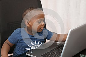 Preschooler e-learning online at home with a laptop