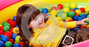 Preschooler girl with ball in play room.