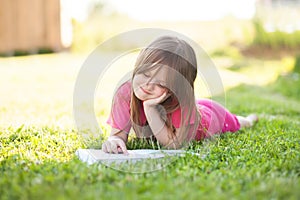 Preschooler girl learn to read outdoors