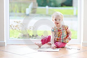 Preschooler girl playing with puzzles on the floor