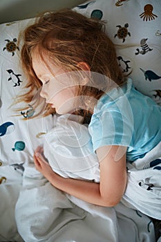 Preschooler girl sleeping in her bed