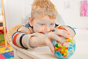 Preschooler with globe in the classroom