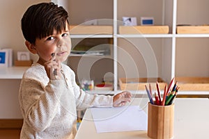 Preschooler kid drawing with coloured pencils. Homeschooling. Learning community. Montessori school