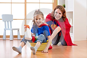 Preschooler kid girl and her mother playing while doing cleanup at home