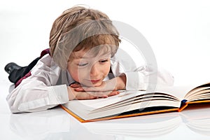 Preschooler reading book while lying on the floor