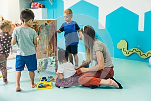 preschoolers painting on the special box in the kindergarten