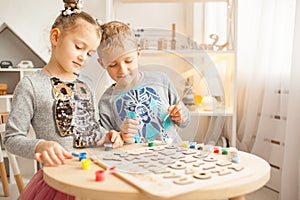 Preschoolers play and learn English letters using wooden alphabet.