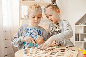 Preschoolers play and learn English letters using wooden alphabet.