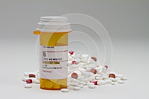 Prescription bottle next to pile of pills, horizontal