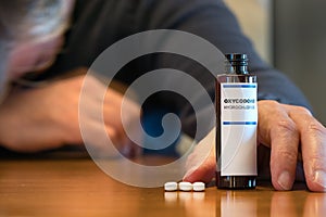 Prescription bottle with Oxycodone tablets on a table