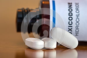 Prescription bottle with Oxycodone tablets on a table. photo