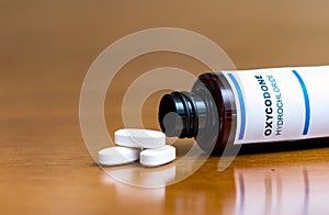 Prescription bottle with Oxycodone tablets on a table photo