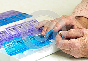 Prescription Drugs In Organizer With Elderly Hands