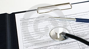 Prescription form lying on table with stethoscope and silver pen