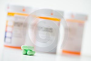 Green capsules in front of orange pharmacy bottles photo