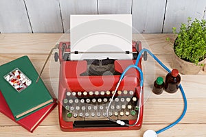 Prescription medicine or medical diagnosis - doctor workplace with stethoscope, pills, typewriter with blank paper on wooden table