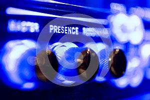 Presence audio sound level knob detail on music amplifier blue neon light photo