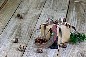 Present, bear ornament and nuts on wood background