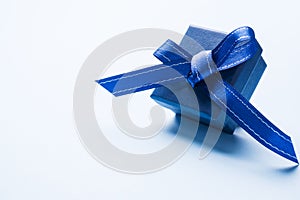 Present blue box on light background greeting card holidays concept. Copy space