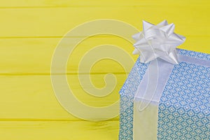 Present box wrapped in blue patterned paper.