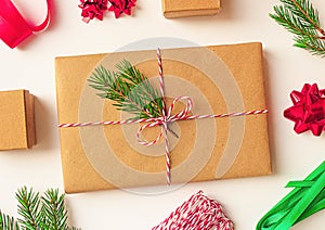 Present box wrapping christmas new year. Craft paper xmas gift box decorated with rope, spruce branch.